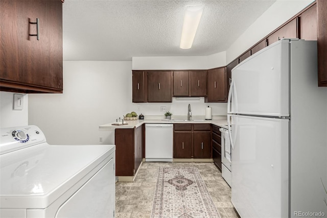 kitchen featuring sink, white appliances, a textured ceiling, and washer / clothes dryer