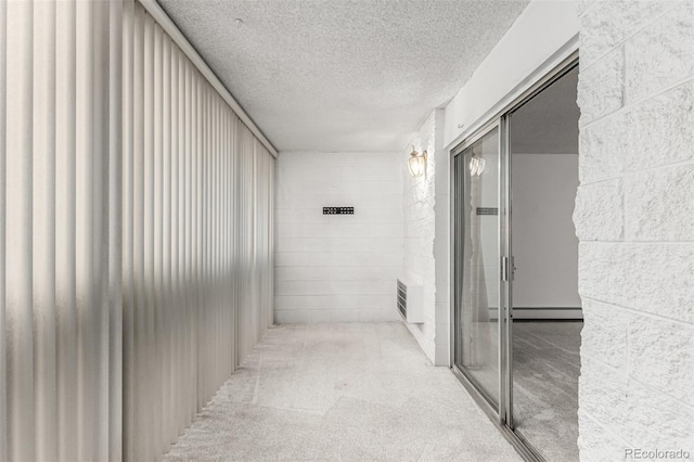 corridor featuring a baseboard radiator, light colored carpet, and a textured ceiling