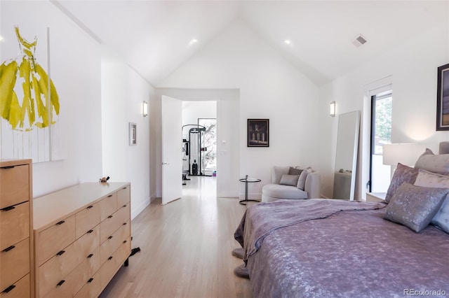 bedroom with high vaulted ceiling and light wood-type flooring