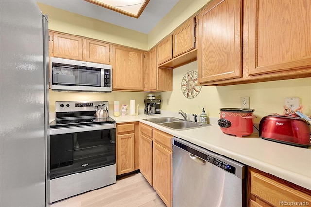 kitchen with light brown cabinetry, appliances with stainless steel finishes, light hardwood / wood-style flooring, and sink