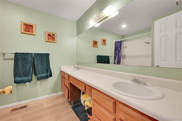 bathroom with wood-type flooring, a shower with shower curtain, and vanity