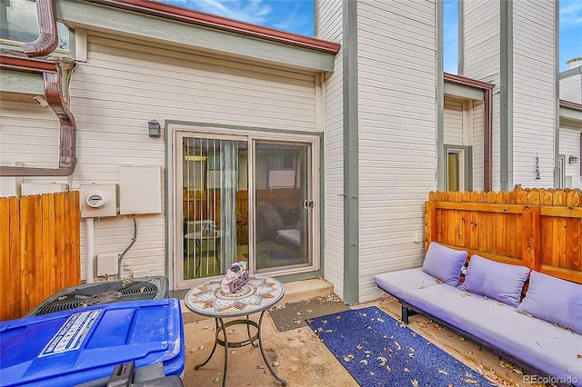 view of exterior entry with a patio and outdoor lounge area