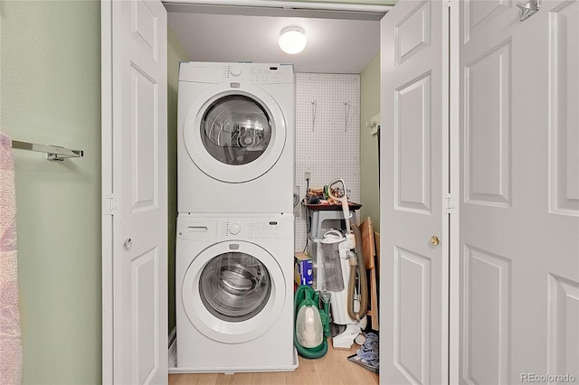 washroom with stacked washer and clothes dryer and hardwood / wood-style floors