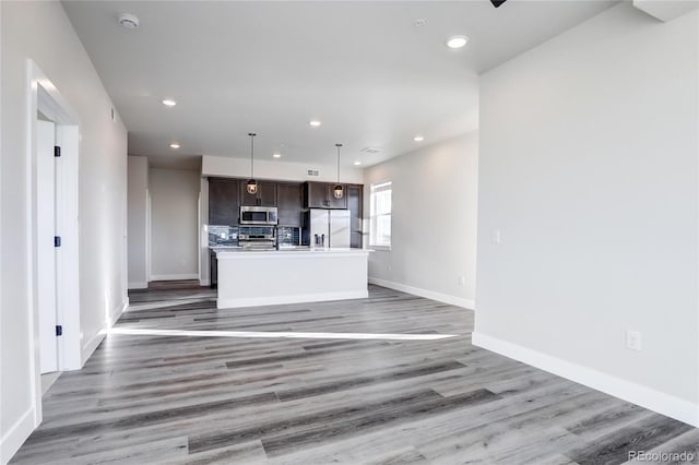 unfurnished living room featuring baseboards, wood finished floors, and recessed lighting