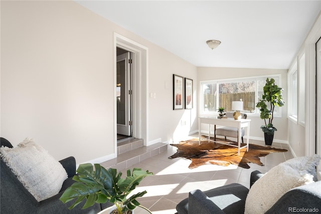 living area with lofted ceiling, baseboards, and light tile patterned flooring