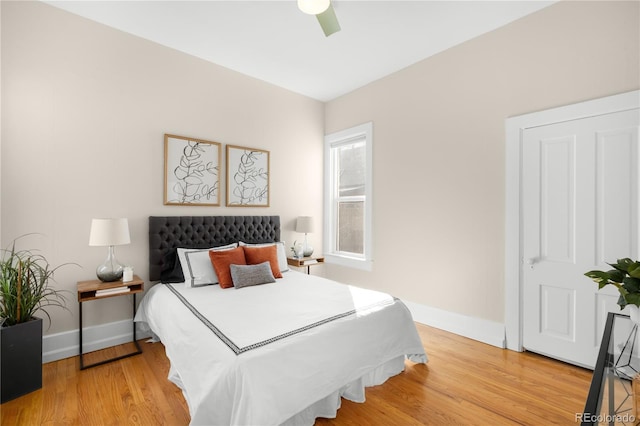 bedroom with ceiling fan, baseboards, and wood finished floors