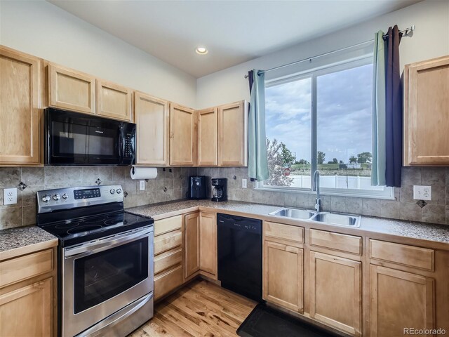 kitchen with light brown cabinets, light hardwood / wood-style flooring, tasteful backsplash, black appliances, and sink