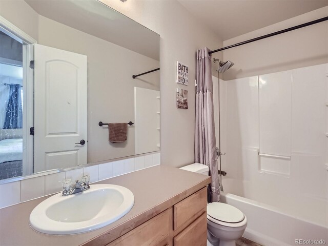 full bathroom featuring toilet, oversized vanity, and shower / bath combo with shower curtain