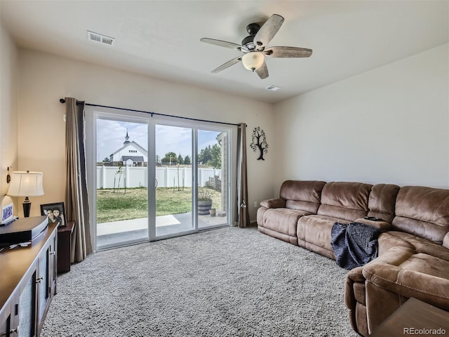 carpeted living room featuring a water view and ceiling fan