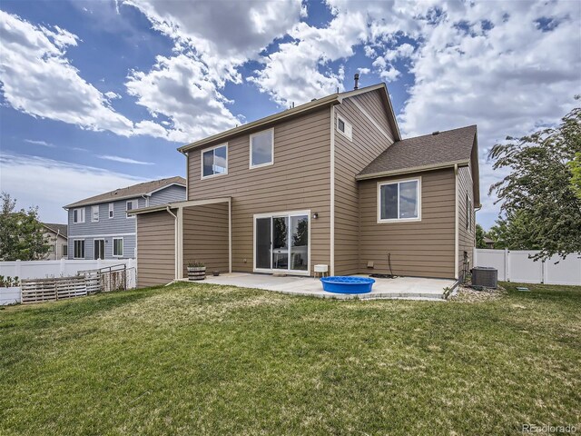 rear view of property featuring a patio, a lawn, and central air condition unit