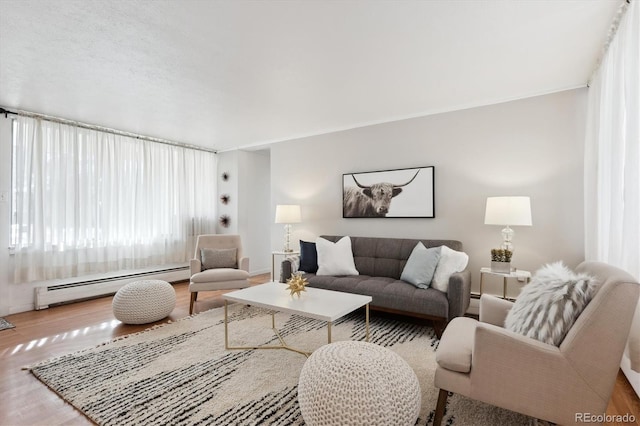 living room with baseboard heating and wood finished floors