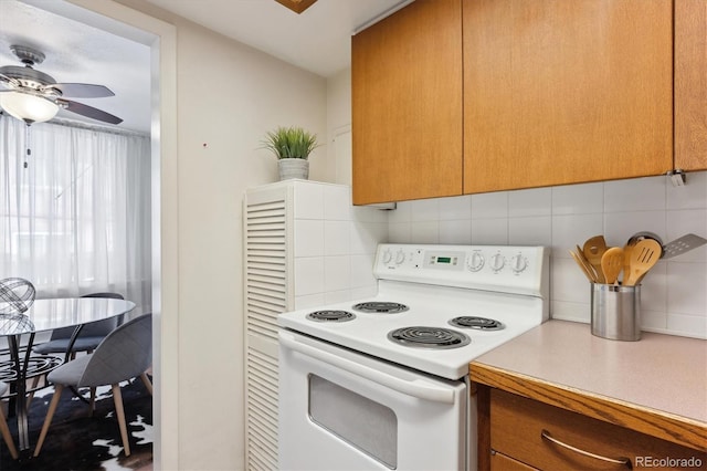 kitchen featuring brown cabinets, light countertops, electric range, decorative backsplash, and ceiling fan