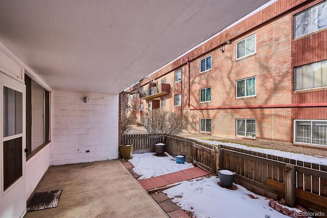 snow covered patio featuring fence