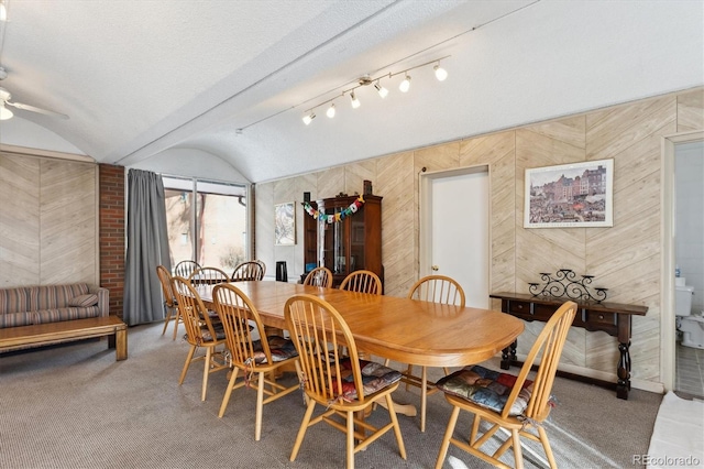 dining room featuring lofted ceiling, ceiling fan, and carpet flooring