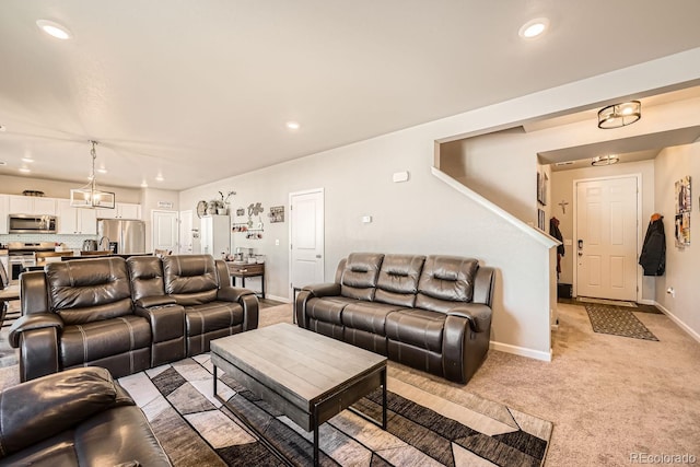 carpeted living room with a notable chandelier