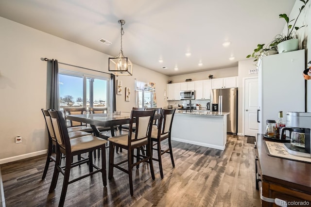 dining room featuring an inviting chandelier and dark hardwood / wood-style floors