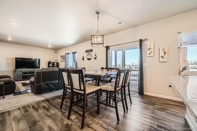 dining space featuring dark hardwood / wood-style floors and a notable chandelier