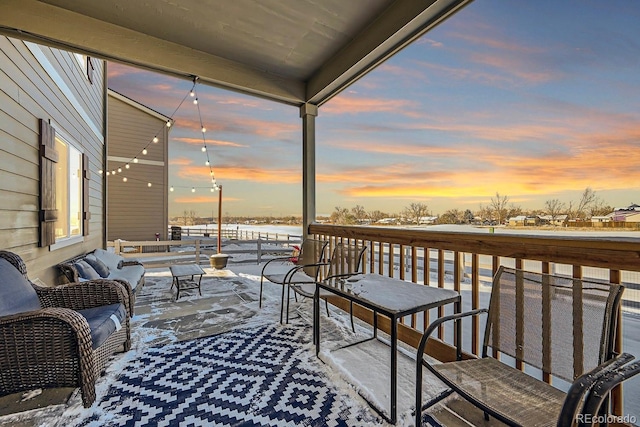 snow covered back of property with an outdoor living space