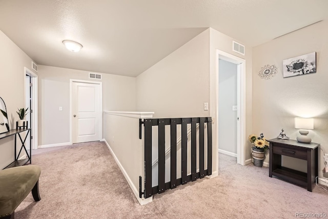 hall with light colored carpet