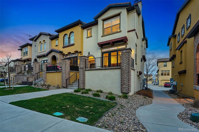 view of front facade with a residential view, stucco siding, and a front yard