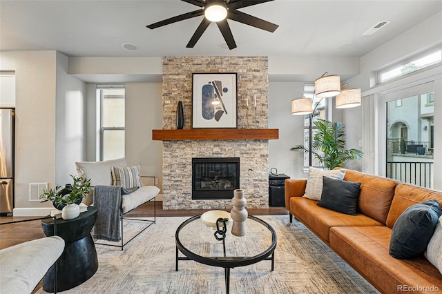 living room featuring visible vents, a ceiling fan, and a healthy amount of sunlight