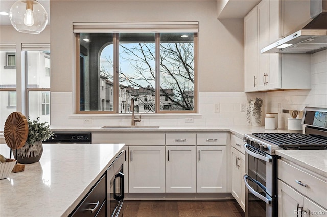 kitchen with tasteful backsplash, a sink, wall chimney exhaust hood, and stainless steel appliances