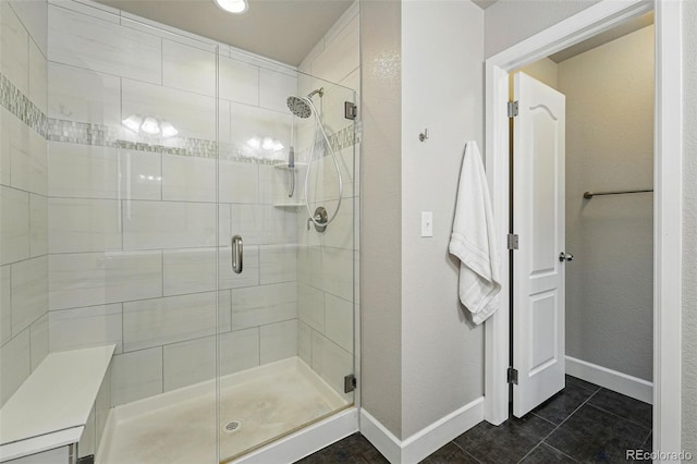 bathroom featuring tile patterned floors, baseboards, and a shower stall
