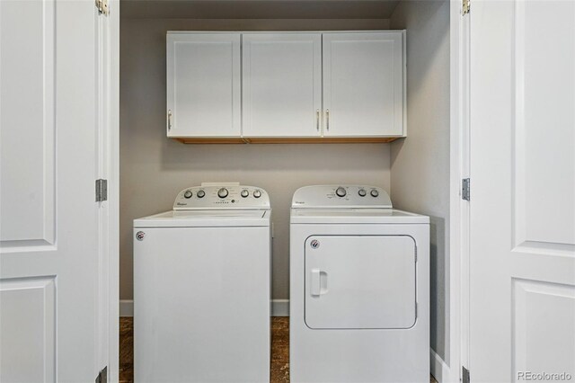 clothes washing area with independent washer and dryer, baseboards, and cabinet space