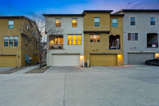 view of property with driveway, stucco siding, and an attached garage