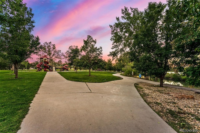 view of property's community featuring a lawn and playground community