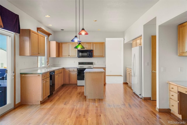 kitchen featuring pendant lighting, black appliances, a center island, and light wood-type flooring