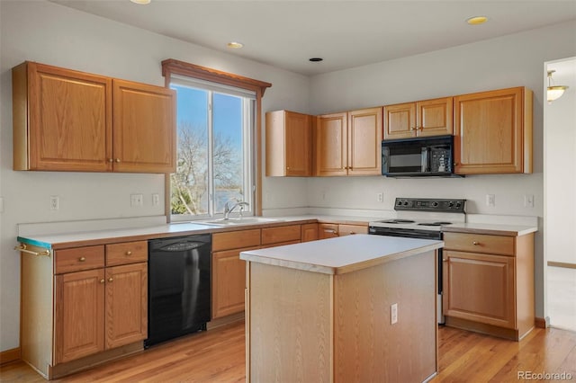 kitchen featuring a kitchen island, sink, light hardwood / wood-style floors, and black appliances