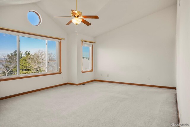 carpeted empty room with plenty of natural light, high vaulted ceiling, and ceiling fan