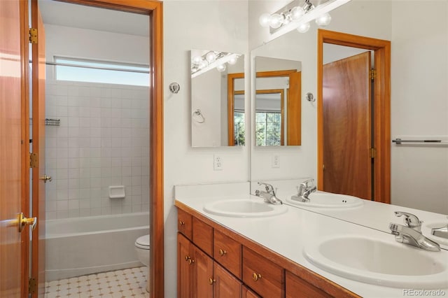 full bathroom with vanity, tiled shower / bath, and toilet