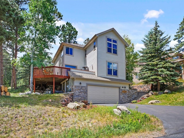 3648 Heatherwood Way, Evergreen, CO 80439 - view of front of home with an attached garage, stone siding, a deck, and asphalt driveway
