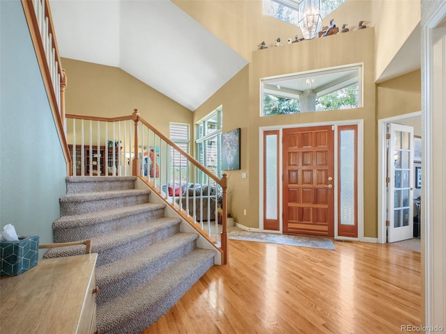 3648 Heatherwood Way, Evergreen, CO 80439 - entrance foyer with a chandelier, wood finished floors, stairs, and high vaulted ceiling