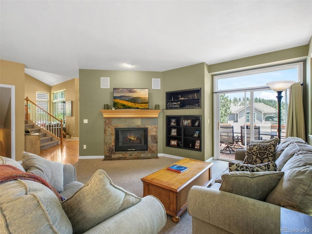 3648 Heatherwood Way, Evergreen, CO 80439 - carpeted living area featuring stairway, a stone fireplace, and plenty of natural light