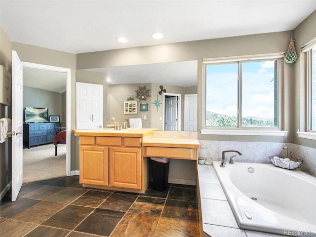 3648 Heatherwood Way, Evergreen, CO 80439 - ensuite bathroom featuring a garden tub, vanity, recessed lighting, and stone finish floors
