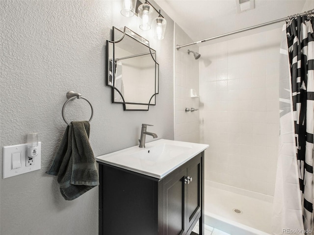 3648 Heatherwood Way, Evergreen, CO 80439 - bathroom with tiled shower, vanity, and a textured wall