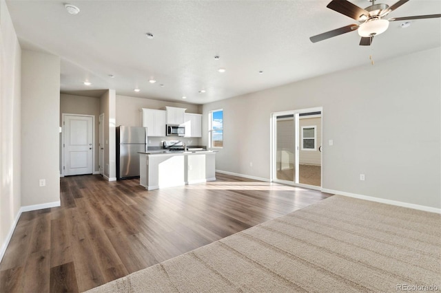 unfurnished living room with recessed lighting, baseboards, dark wood-type flooring, and ceiling fan