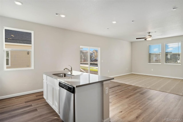 kitchen with stainless steel dishwasher, light wood-style flooring, baseboards, and a sink