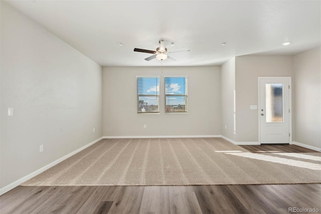 interior space featuring baseboards, wood finished floors, and a ceiling fan