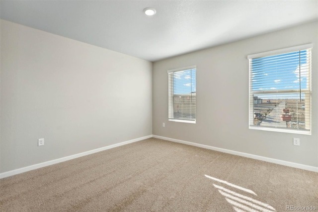 carpeted empty room featuring baseboards