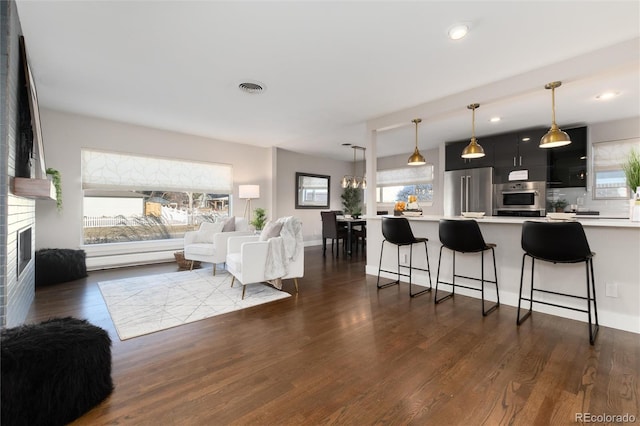 living room featuring a brick fireplace and dark hardwood / wood-style floors