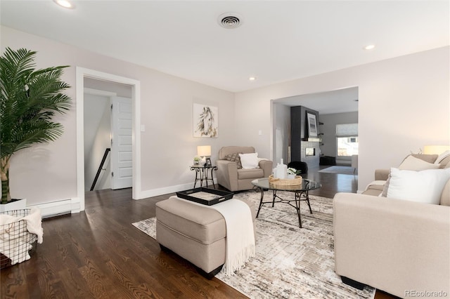 living room with a baseboard heating unit and dark wood-type flooring