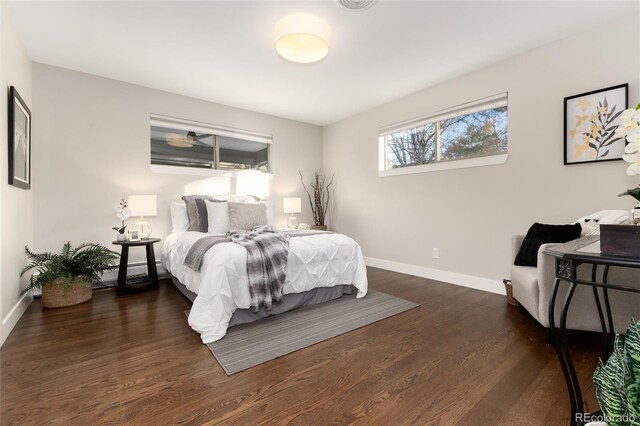 bedroom with a baseboard radiator and dark wood-type flooring