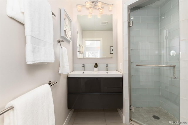 bathroom featuring tile patterned flooring, a shower with shower door, and vanity