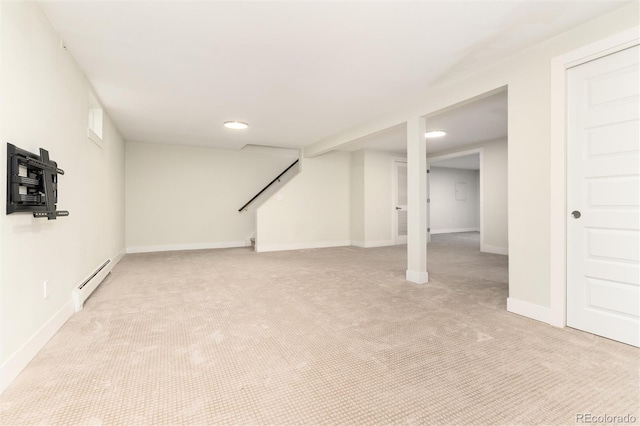 basement featuring a baseboard heating unit and light carpet