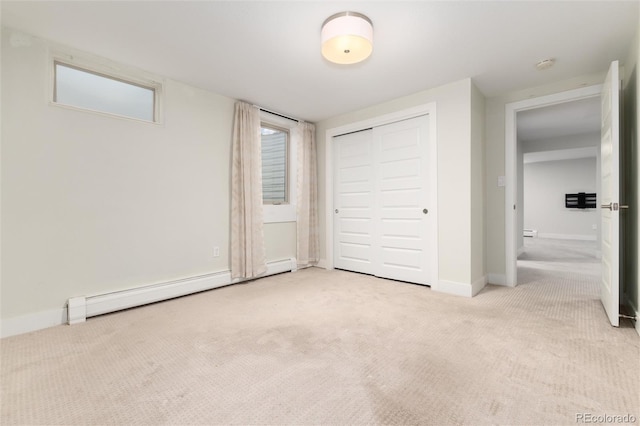 unfurnished bedroom featuring a closet, light carpet, and a baseboard heating unit