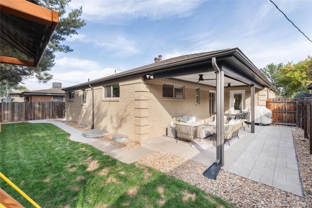 back of house featuring ceiling fan, a lawn, and a patio area